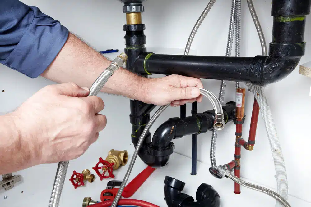 Man Holding Pipes — Blocked Drain Services In Palm Beach, QLD