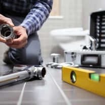 Plumber at work in a bathroom — Professional Blocked Drain Plumber, QLD