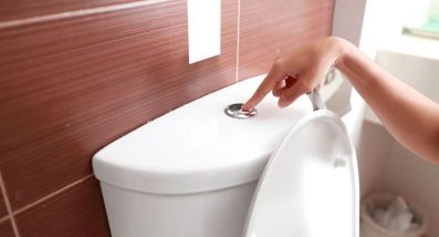 Woman flushing a toilet with blocked drain — Experts in Blocked Drain Gold Coast