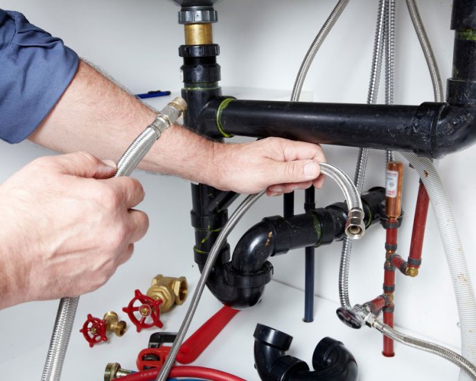 Man Holding Pipes — Blocked Drain Services In Palm Beach, QLD