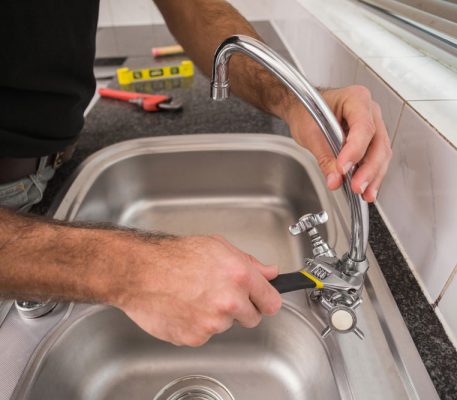 Plumber fixing the sink with wrench — Blocked Drain Services In Palm Beach, QLD