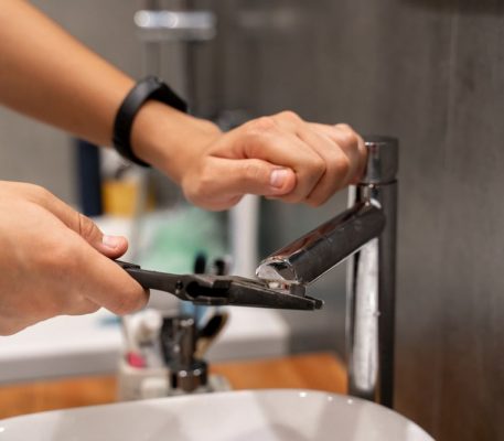 A Plumber Repairing A Faucet