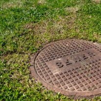 Sewer entry grate in the middle of a lawn — Professional Blocked Drain Plumber, QLD